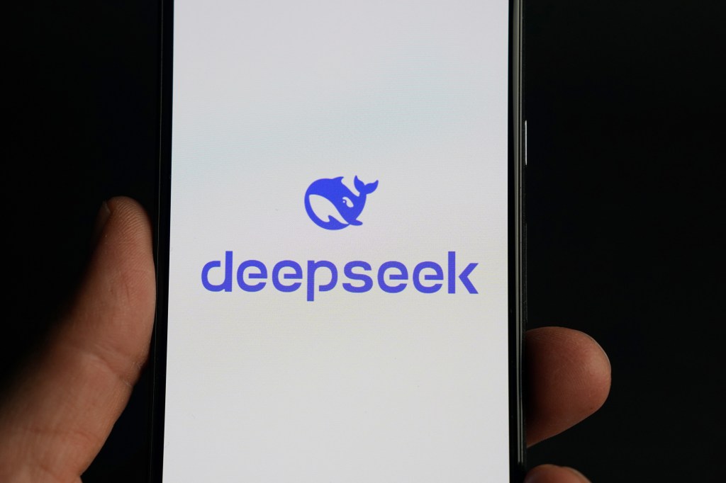 Hand holding a smartphone displaying the Deepseek Logon, Chinese Artificial Intelligence Application