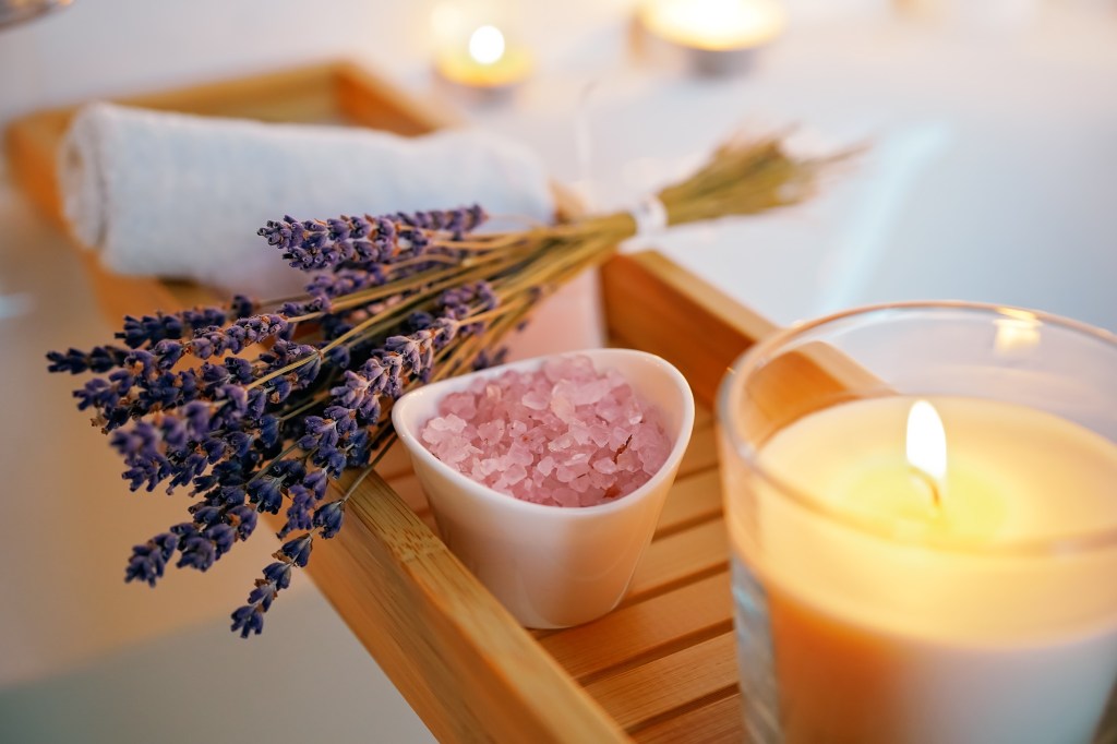 Ritual cleaning bath of the spiritual aura for the full moon ritual. Candles, aroma salt and lavender on the tub table, near